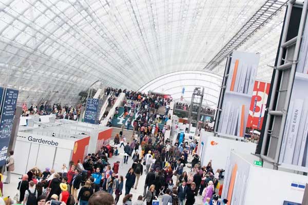 Crowd inside a large convention hall using courier services